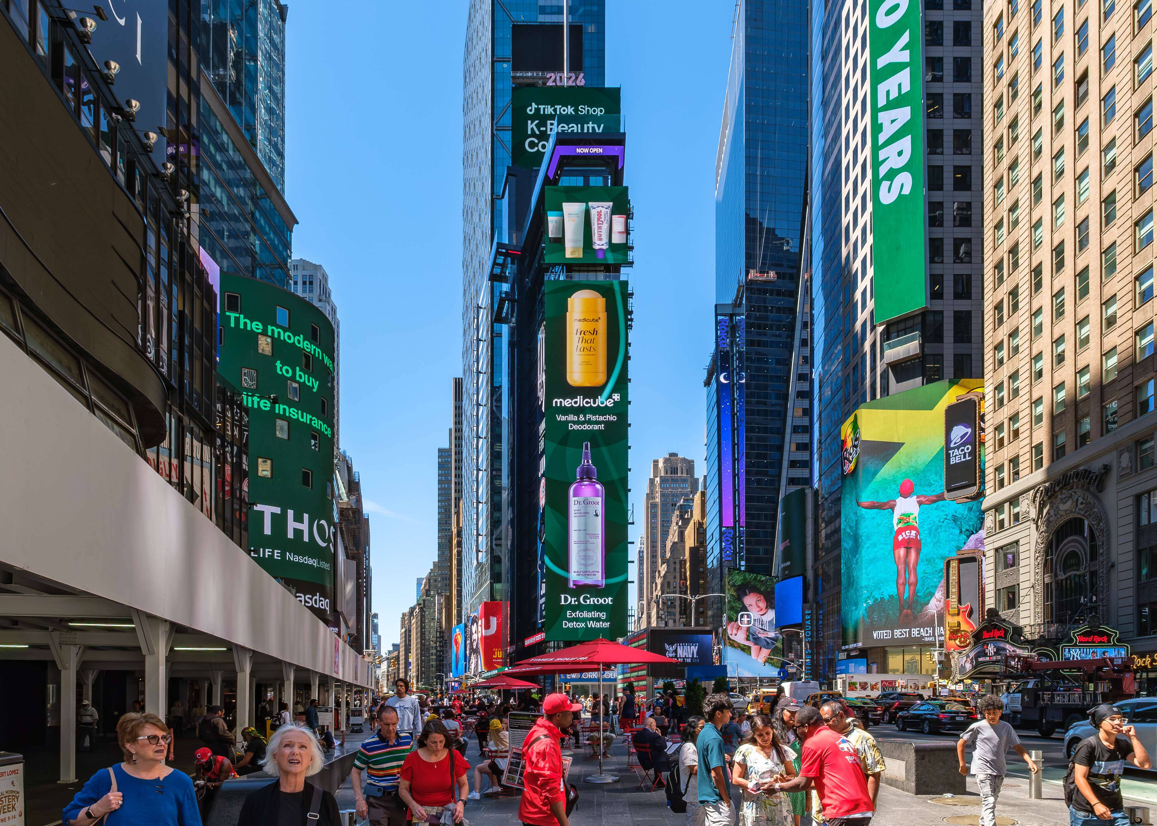 TikTok Shop K-Beauty Collective medicube and Dr. Groot product creatives on the vertical digital screens above the Times Square pedestrian plaza